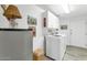 Efficient laundry room equipped with a washer, dryer, and storage cabinets with tiled floors and walls at 955 E Knox Rd # 137, Chandler, AZ 85225