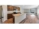 Kitchen with stainless appliances, a granite island, and wood-look flooring that flows into the living space at 1050 W West Virginia Ave, Florence, AZ 85132