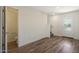 Open-concept area showcasing wood-look flooring, access to a half-bath, and entry to upper level at 1091 W West Virginia Ave, Florence, AZ 85132