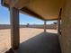Covered patio with concrete flooring overlooking a spacious, enclosed dirt backyard at 1091 W West Virginia Ave, Florence, AZ 85132