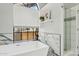 Bright bathroom with white marble tile, white tub beneath a window, and a glass enclosed shower at 11011 N 92Nd St # 1005, Scottsdale, AZ 85260