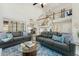 Spacious living room with soaring ceilings, open staircase, and comfortable sofas on top of a blue rug at 11011 N 92Nd St # 1005, Scottsdale, AZ 85260