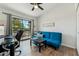 Bright office features a blue futon, a black desk, and a large window with views of the outside at 11011 N 92Nd St # 1005, Scottsdale, AZ 85260