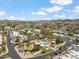 Community aerial with meticulously planned streets, green spaces, and a shared pool area amidst a mountain range view at 113 E Boca Raton Rd, Phoenix, AZ 85022