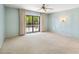 Spacious main bedroom with wall sconces, neutral carpet, and sliding glass door to backyard at 113 E Boca Raton Rd, Phoenix, AZ 85022