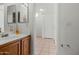 Bathroom with tile flooring, wooden vanity, and a mirrored wall cabinet at 11710 W Paradise Dr, El Mirage, AZ 85335