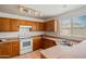 Bright kitchen showcasing a range oven, wood cabinets, sink, and a window at 11710 W Paradise Dr, El Mirage, AZ 85335