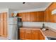 Kitchen area featuring stainless steel refrigerator, wooden cabinets, and light countertops at 11710 W Paradise Dr, El Mirage, AZ 85335
