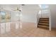 Bright living room featuring tile floors, a ceiling fan, and stairway access to the second floor at 11710 W Paradise Dr, El Mirage, AZ 85335