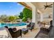 Outdoor patio area featuring wicker seating, a ceiling fan, and a pool, perfect for entertaining and relaxation at 11993 E Mission Ln, Scottsdale, AZ 85259