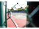 Community tennis court ready for a match, behind a green chainlink fence with a visible tennis net at 11993 E Mission Ln, Scottsdale, AZ 85259