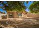 Wide view of the house backyard featuring mature trees, block wall and covered patio at 12355 W Hadley St, Avondale, AZ 85323