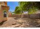 Spacious backyard with rock landscaping, mature trees, and block wall fencing at 12355 W Hadley St, Avondale, AZ 85323