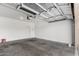 Clean garage interior featuring a roll-up door, fresh paint and concrete floors at 12355 W Hadley St, Avondale, AZ 85323