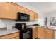 Efficient kitchen featuring wood cabinets and black appliances at 12355 W Hadley St, Avondale, AZ 85323