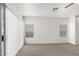 Bright living room with neutral carpet, white walls and window blinds at 12355 W Hadley St, Avondale, AZ 85323