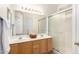 Well-lit main bathroom with double sinks, a large mirror, and a separate shower area at 12355 W Hadley St, Avondale, AZ 85323