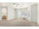 Spacious main bedroom featuring neutral carpet, ceiling fan, and natural light from large windows at 12355 W Hadley St, Avondale, AZ 85323