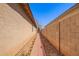 Narrow walkway between homes featuring red brick and a block fence at 12355 W Hadley St, Avondale, AZ 85323