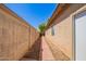 Narrow walkway between homes featuring red brick and a block fence at 12355 W Hadley St, Avondale, AZ 85323