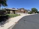 Street-level view of desert home with attached garages, beige stucco and tile roof at 12938 W Alvarado Rd, Avondale, AZ 85392