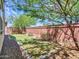 This backyard offers a brick wall, desert plants and foliage and an artifical lawn at 14160 W Georgia Dr, Surprise, AZ 85379