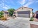 The front of this home has a two-car garage and desert landscaping at 14160 W Georgia Dr, Surprise, AZ 85379