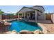 Backyard with private pool, covered patio and desert landscaping is ideal for enjoying the outdoors at 14895 W Jenan Dr, Surprise, AZ 85379