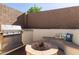 Backyard with outdoor kitchen and gas grill, fire pit seating and a concrete block fence at 14895 W Jenan Dr, Surprise, AZ 85379