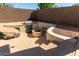 Backyard with outdoor kitchen, seating area around a fireplace, and concrete steps at 14895 W Jenan Dr, Surprise, AZ 85379