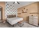 Neutral bedroom with accent wall, ceiling fan and wooden furniture at 14895 W Jenan Dr, Surprise, AZ 85379