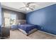 Cozy bedroom with blue accent wall and ceiling fan at 14895 W Jenan Dr, Surprise, AZ 85379