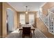 Bright dining room with wood table, neutral walls, and a staircase at 14895 W Jenan Dr, Surprise, AZ 85379