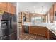 Spacious kitchen with wood cabinets, stainless steel fridge, and quartz countertops at 14895 W Jenan Dr, Surprise, AZ 85379