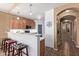 Open-concept kitchen with bar seating, warm wood cabinets, and a view into the hallway at 14895 W Jenan Dr, Surprise, AZ 85379