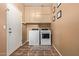 Laundry room with a tile floor, front loading washer/dryer, and storage space above the units at 14895 W Jenan Dr, Surprise, AZ 85379
