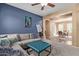 Cozy living room featuring a plush gray sectional, and a modern blue accent wall at 14895 W Jenan Dr, Surprise, AZ 85379