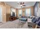 Living room with plush sectional, ceiling fan, and natural light at 14895 W Jenan Dr, Surprise, AZ 85379