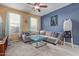 Comfortable living room with plush sectional, ceiling fan, and natural light at 14895 W Jenan Dr, Surprise, AZ 85379
