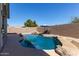 A backyard pool and patio features a waterfall, desert landscaping, and shaded lounge area at 14895 W Jenan Dr, Surprise, AZ 85379