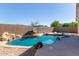 Sparkling pool features a rock waterfall and ample space for relaxation and entertaining in this backyard oasis at 14895 W Jenan Dr, Surprise, AZ 85379