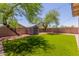 Lush backyard with synthetic grass, shade trees, storage shed, and block wall at 14919 W Hearn Cir, Surprise, AZ 85379