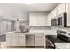 Bright kitchen featuring stainless steel appliances, white cabinetry, and easy access to living space at 14919 W Hearn Cir, Surprise, AZ 85379