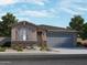 Inviting single-story home featuring a mix of stone veneer and stucco, with gray shutters and a two-car garage at 15997 W Bronco Trl, Surprise, AZ 85387