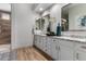 Bright bathroom with granite countertops, and sinks, and wood look floors at 16373 W Beautiful Ln, Goodyear, AZ 85338