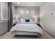 Bright bedroom featuring a queen bed, modern lamps, neutral paint, and decorative wall art at 16373 W Beautiful Ln, Goodyear, AZ 85338