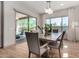 Inviting dining room with modern lighting, table decor, and sliding door to the outdoor space at 16373 W Beautiful Ln, Goodyear, AZ 85338