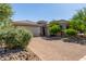 Single-story home showcasing a two-car garage, brick driveway, desert landscaping and neutral paint scheme at 16373 W Beautiful Ln, Goodyear, AZ 85338