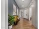 Bright hallway featuring wood floors, a stylish bench, and an eye-catching art at 16373 W Beautiful Ln, Goodyear, AZ 85338