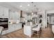 Bright kitchen featuring white cabinets, stainless appliances, granite countertops, and island seating at 16373 W Beautiful Ln, Goodyear, AZ 85338